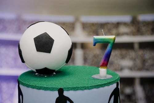 Delicious birthday cake with football theme and number candle