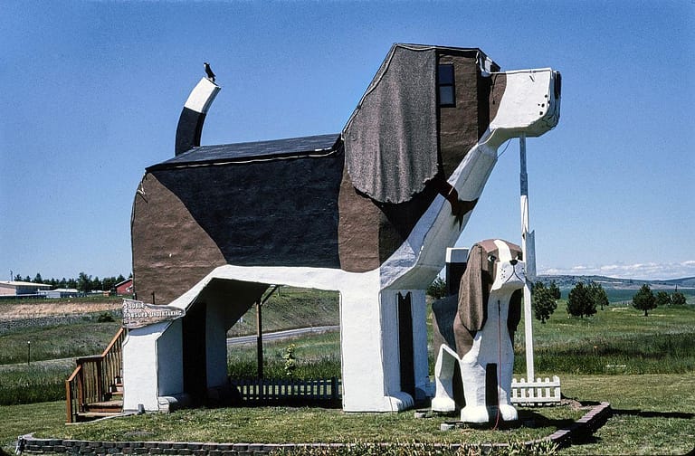 Dog Bark Park Bed & - a dog statue in front of a house