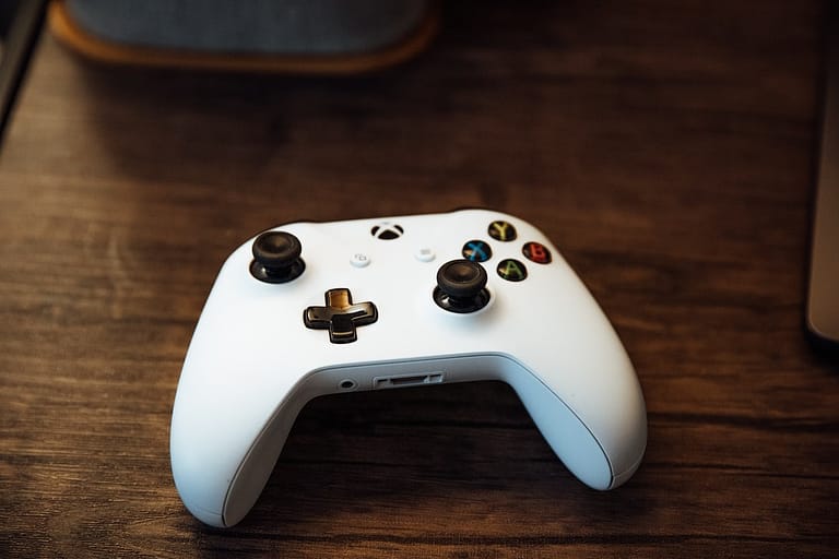 selective focus photography of white Xbox controller on brown table